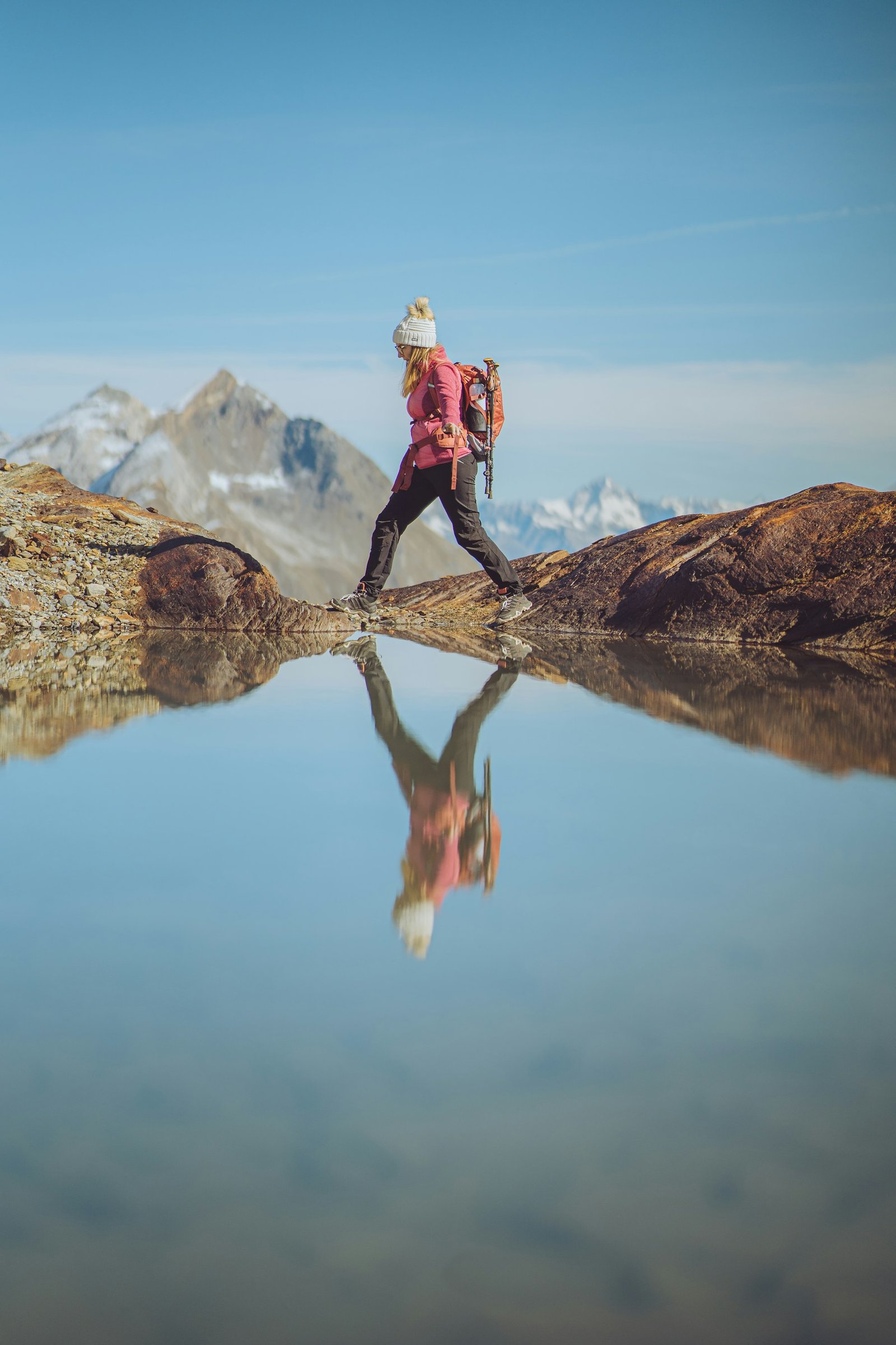 Hiker surveying a mountain lake from a rocky ridge