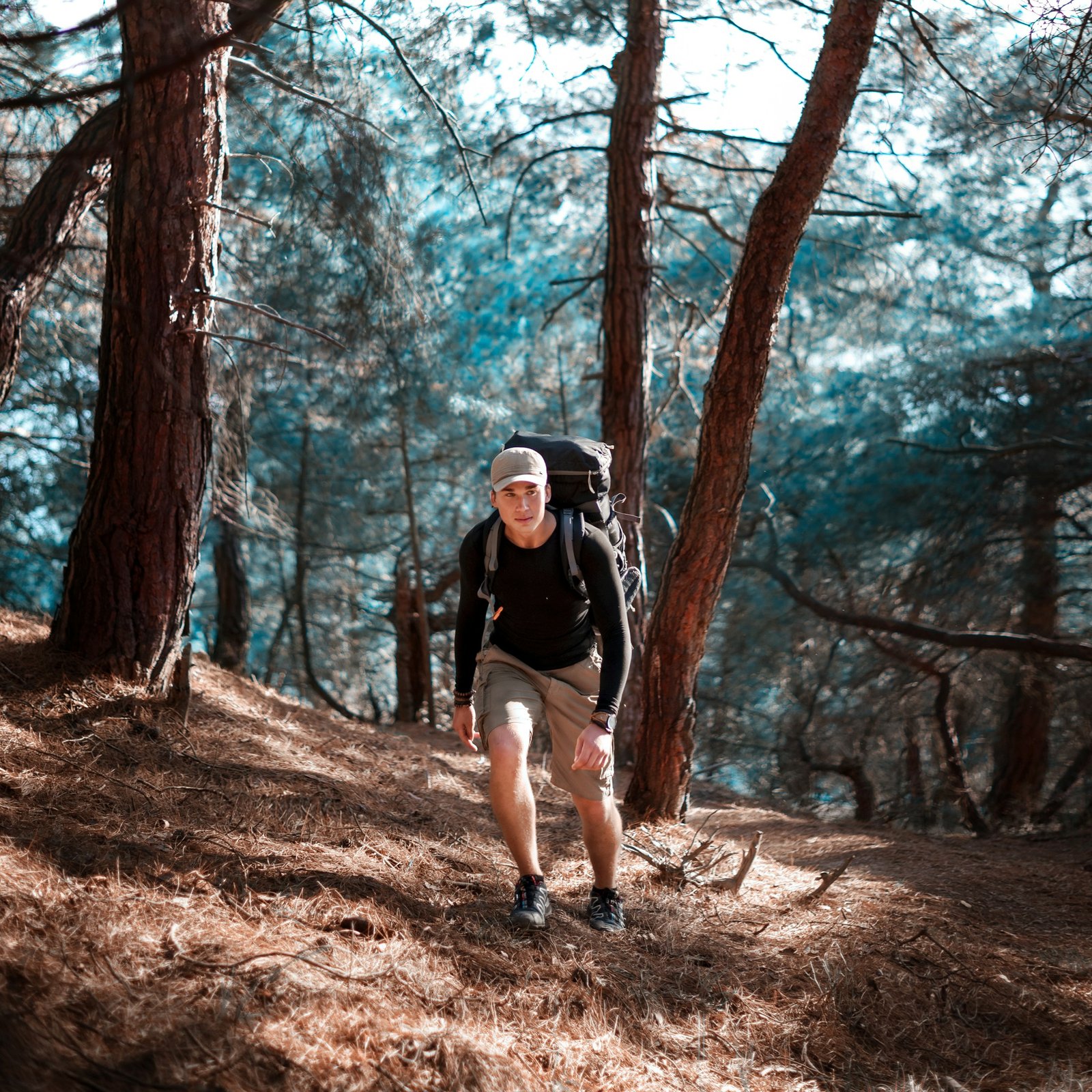 Hiker crossing an exposed alpine trail with a field pack